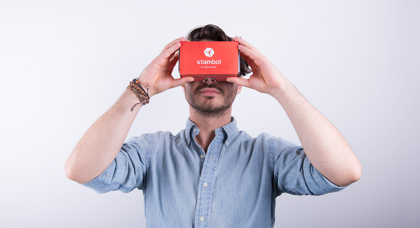 male model holding Google Cardboard with Stambol logo